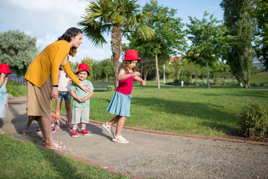 Children and a nanny enjoy playing in a sunny park, perfect for outdoor activities.